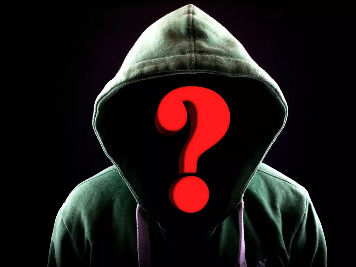 A hooded figure with a red question mark over their face.